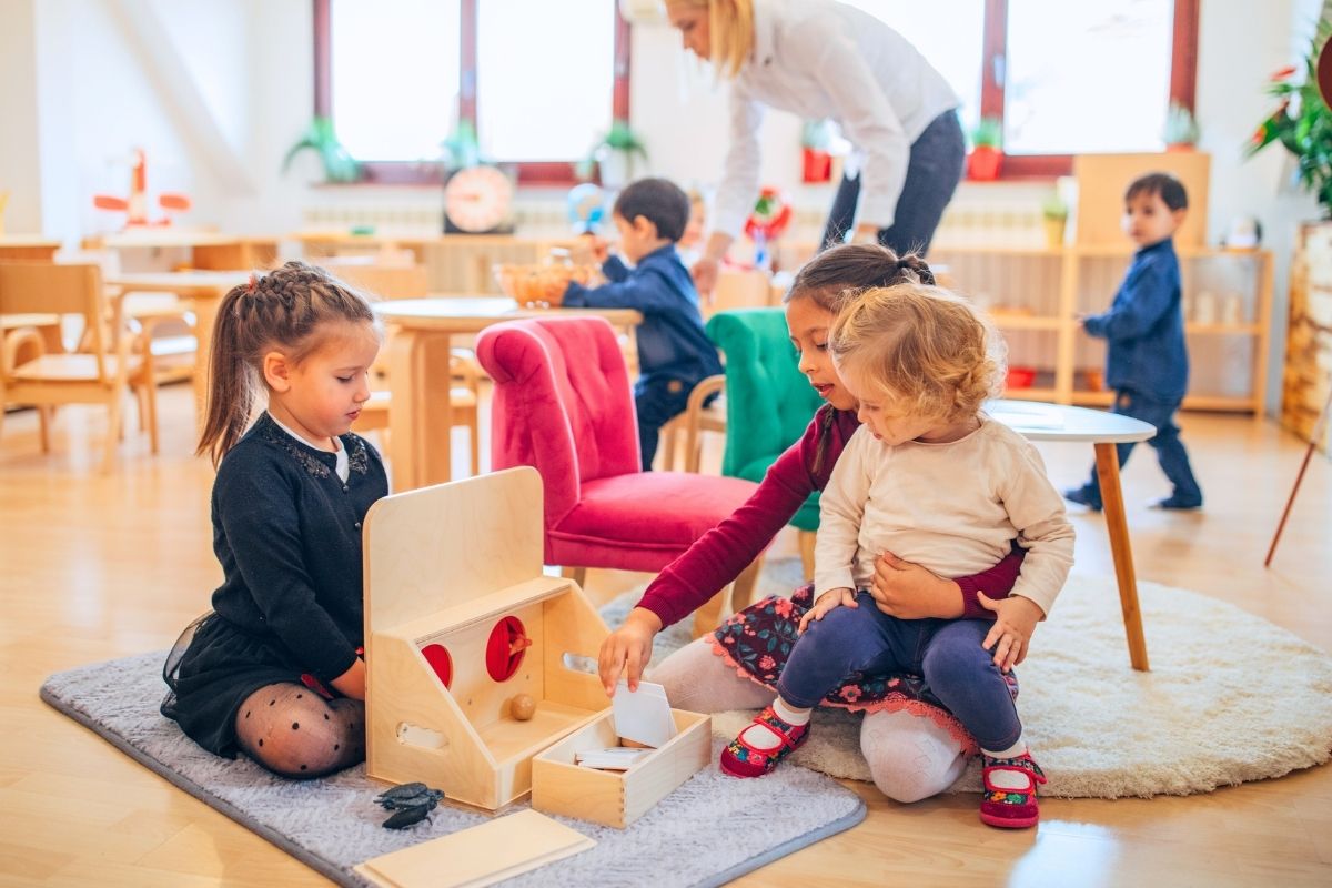 Children in a mixed age class at a Montessori preschool storing materials
