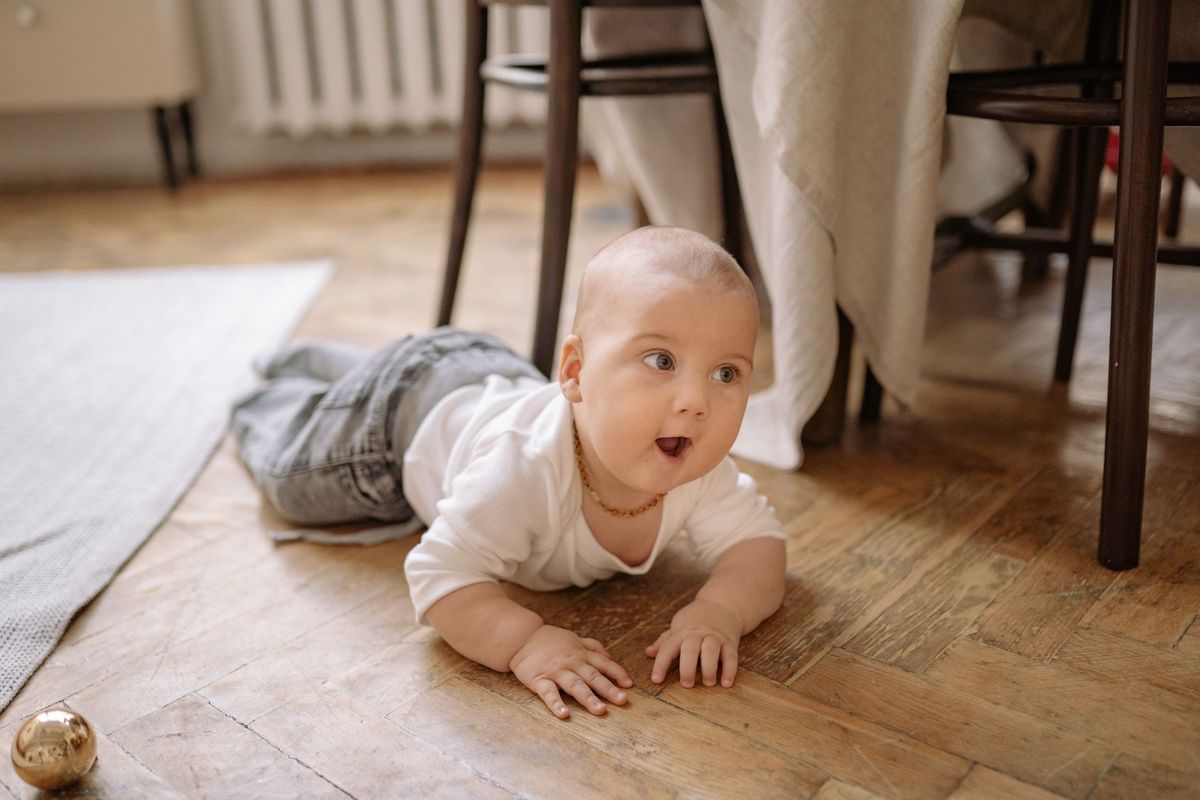 Baby crawling on a wooden floor