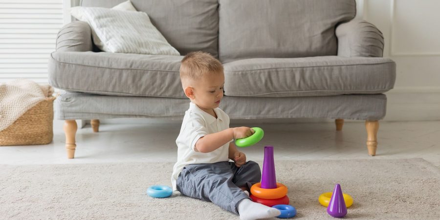 Toddler stacking rings on a rug