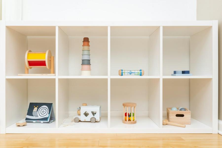 Low white shelf with a few wooden toys