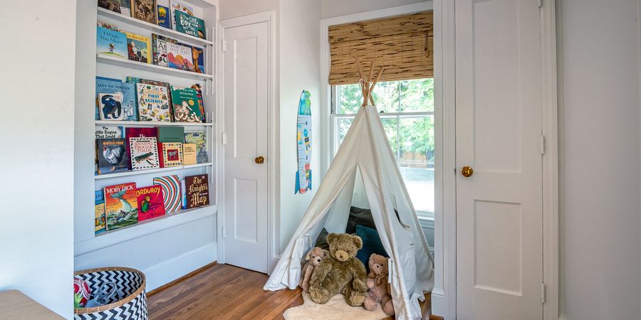 Reading corner with front-facing books and a play tent