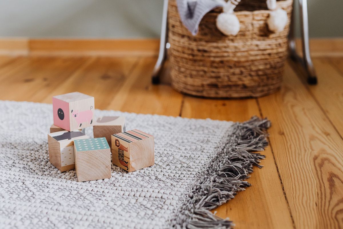 A few wooden blocks on a woven rug