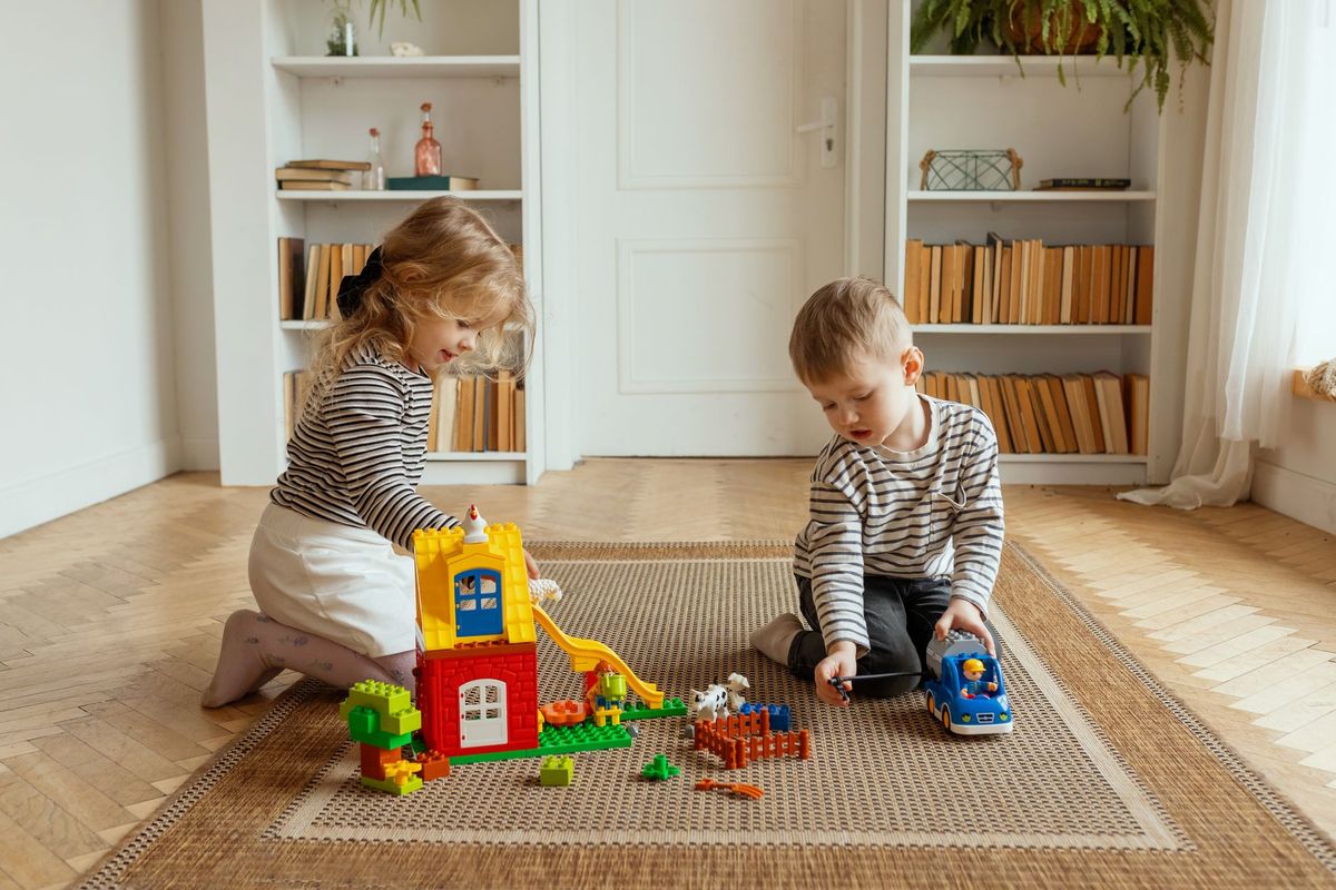 Two children playing between low bookshelves