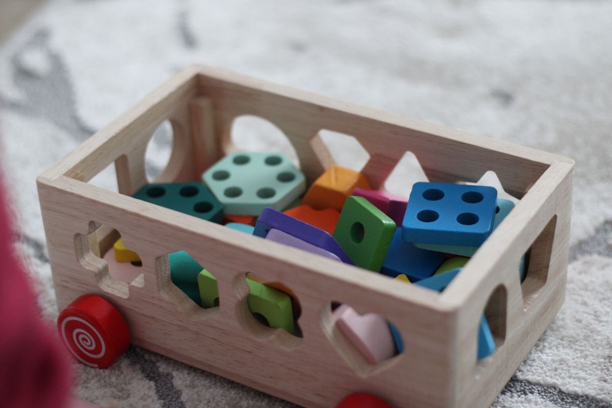 Wooden shape sorter cart filled with colorful blocks