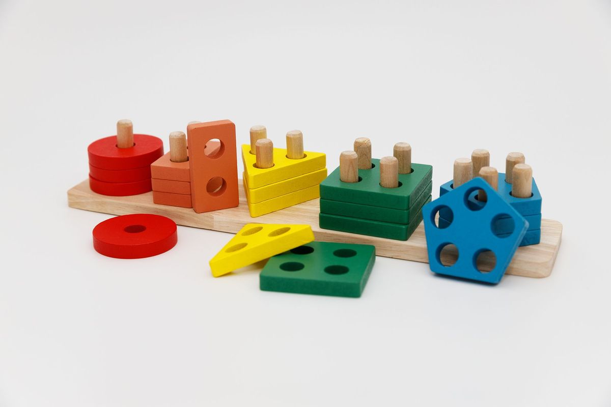 Wooden stacking and sorting toy with colored shapes on pegs